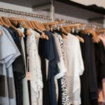 Vibrant clothing display on wooden hangers in a modern boutique setting.